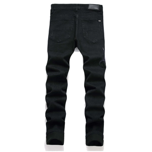 Detailansicht der schwarzen Jeans mit lila Stickerei und Marken-Lederetikett am Bund