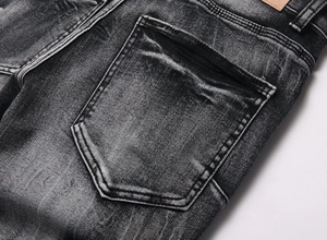 Close-up of vintage washed black denim rear pocket with reinforced stitching and leather label