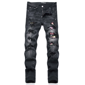 Jeans slim neri effetto consumato con toppe colorate e schizzi di vernice bianca