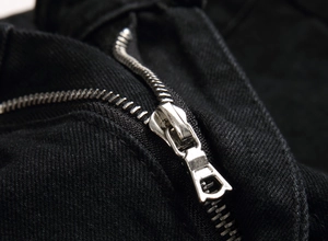 Nahaufnahme des hochwertigen Metallreißverschlusses und der schwarzen Denim-Stoffstruktur