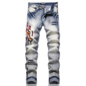 Slim fit men's blue jeans featuring tiger head embroidery and washed denim textures