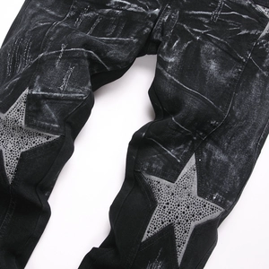 Men's black slim fit flare jeans featuring acid wash finish and rhinestone star patches
