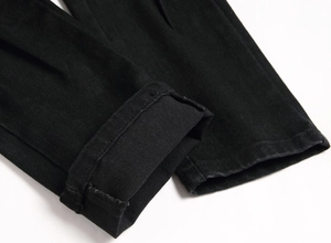 Detail des Saums schwarzer Distressed-Jeans mit sauberen Nähten und hochwertigem Stoff
