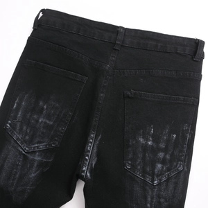 Men's black slim fit flared jeans with heavy distressed white paint splatter on back