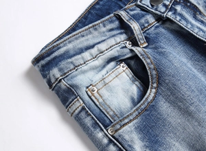 Detail der blauen Stretch-Jeans mit Taillennähten und Metallnieten-Verstärkung am Bund