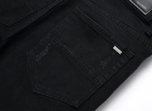 Nahaufnahme der schwarzen Denim-Gesäßtasche mit Lederpatch und Used-Look-Details
