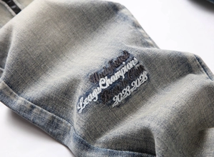 Detailed close-up of tiger head embroidery and blue snowflake wash denim texture