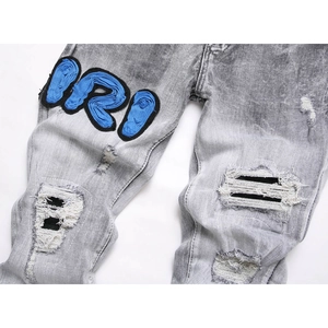 Men's washed gray slim jeans featuring heavy distressed rips and blue RD embroidered patch