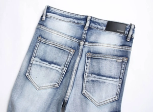 Detailansicht der blau gewaschenen Jeans mit gesticktem Logo und schwarzem Lederetikett