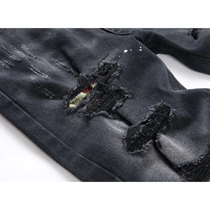 Jeans slim neri strappati con toppe colorate e dettagli con schizzi di vernice bianca