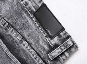 Close-up of the waistband with black leather patch and acid wash denim texture