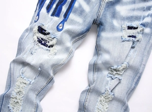 Détail du jean skinny bleu avec broderies à paillettes et ornements de pierres précieuses