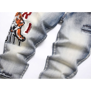 Slim fit light blue jeans featuring vintage tiger head embroidery and patchwork details