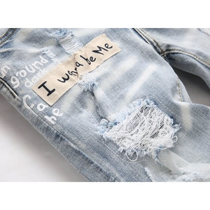 Blue distressed skinny jeans with ripped details and 'I wanna be Me' canvas patch