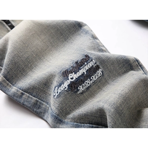 Vintage blue stretch denim jeans featuring detailed League Champion tiger embroidery