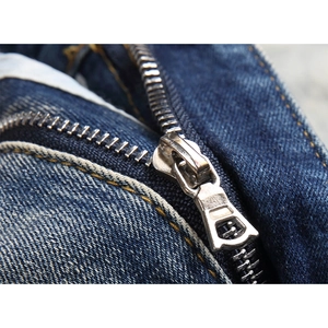 Detail of blue stretch denim jeans with a silver metal zipper and yellow stitching