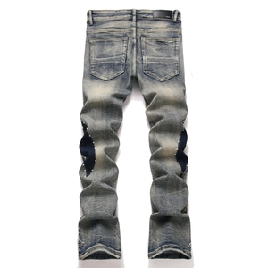 Vue détaillée du dos d'un jean délavé avec patchwork en croissant et broderie de perles