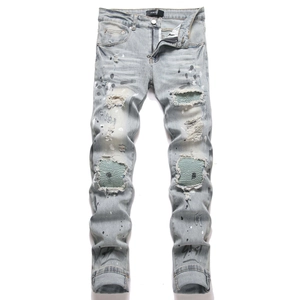 Men's slim fit light blue ripped jeans with paint splatters and pleated knee patches