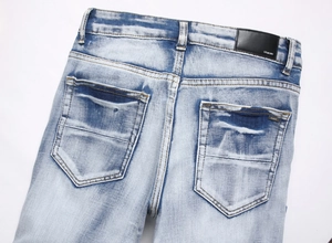 Vue détaillée de la poche arrière en denim avec patch en cuir et badge logo métallique