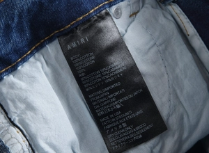 Vue macro de l'étiquette AMIRI en denim indiquant Made in USA et les conseils de soin