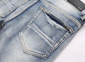 Detailed macro view of the blue washed denim texture with yellow stitching and leather tag