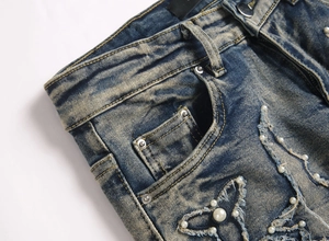 Détail du jean évasé bleu ajusté avec perles artisanales et finitions usées de haute qualité