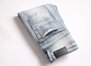 Detailed view of blue denim back pocket with leather brand patch and premium stitching