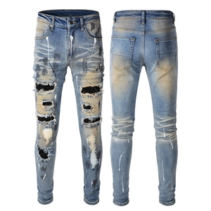 Men's slim fit distressed light blue jeans with splatter ink and ripped patch details