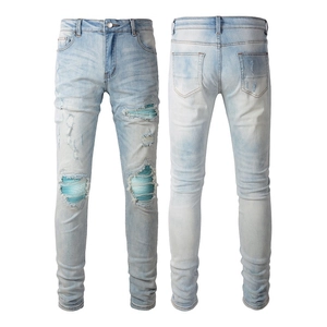 Slim fit light blue distressed jeans with knee patches and faded wash for men