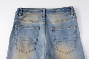 Macro shot of back pockets and vintage dirty wash detail on blue denim jeans