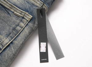 Détail de la texture denim bleu avec plaque en métal argenté et étiquette de marque