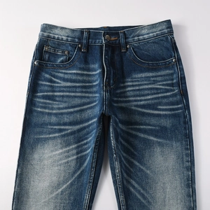 Slim fit flared blue denim jeans for men with vintage whiskers and heavy denim texture