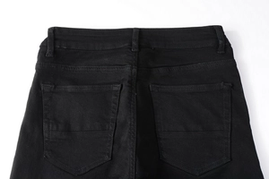 Detailansicht der Rückseite der schmalen schwarzen Herrenjeans mit Taschennähten und Denim-Struktur