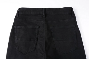 Close-up of high-waisted black denim jeans showing rear pockets and waistband detail