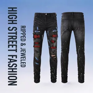 Men's slim fit black ripped jeans with red rhinestone patches and paint splatters