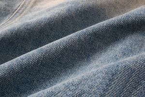 Close-up of blue denim fabric with twill texture and natural washed faded finish