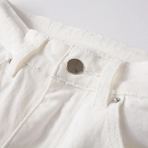Detailed close-up of white denim jeans waistband with silver metal button and rivets