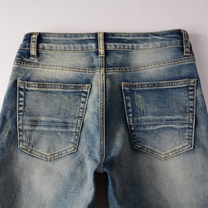Macro shot of back pockets on light blue distressed jeans with worn-out texture