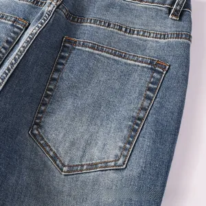 Détail de couture de la poche arrière et texture denim sur jean évasé bleu homme