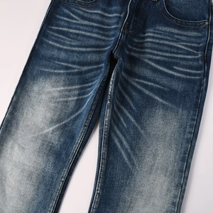 Detail of deep blue flare jeans showing heavy stone wash effects and whiskers texture