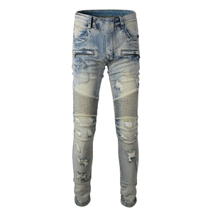 Close-up of distressed Moto panels and metal zipper pocket on light blue denim jeans