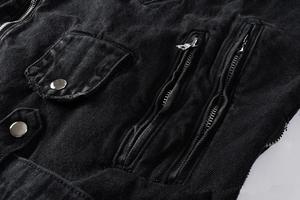 Detailed close-up of heavy washed black denim jacket with metallic zippers and snap pockets