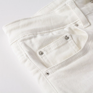 Detail of white denim jeans waist and pockets with silver metal rivets and stitching