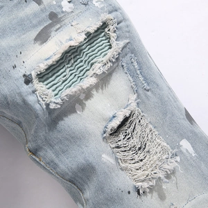 Blue street-style slim-fit ripped jeans featuring paint splatters and distressed patches