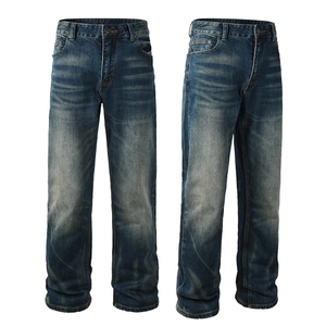 Detail of dark blue straight leg denim pants showing washed texture and whiskering effects