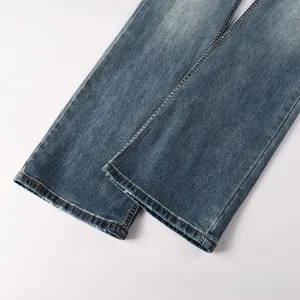 Détail du bas de jean évasé bleu délavé avec ourlet effiloché et moustaches rétro usées