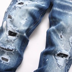 Distressed blue slim fit jeans with heavy wash, embroidery and white paint splatter