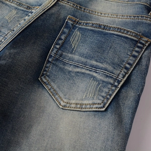 Close-up detail of high-street biker jeans back pocket with worn distressed finish