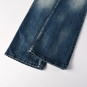 Detailed macro shot of flared jeans hem with snow wash and faded denim texture
