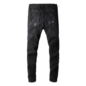 Close-up of distressed details and ripped textures on black streetwear denim jeans